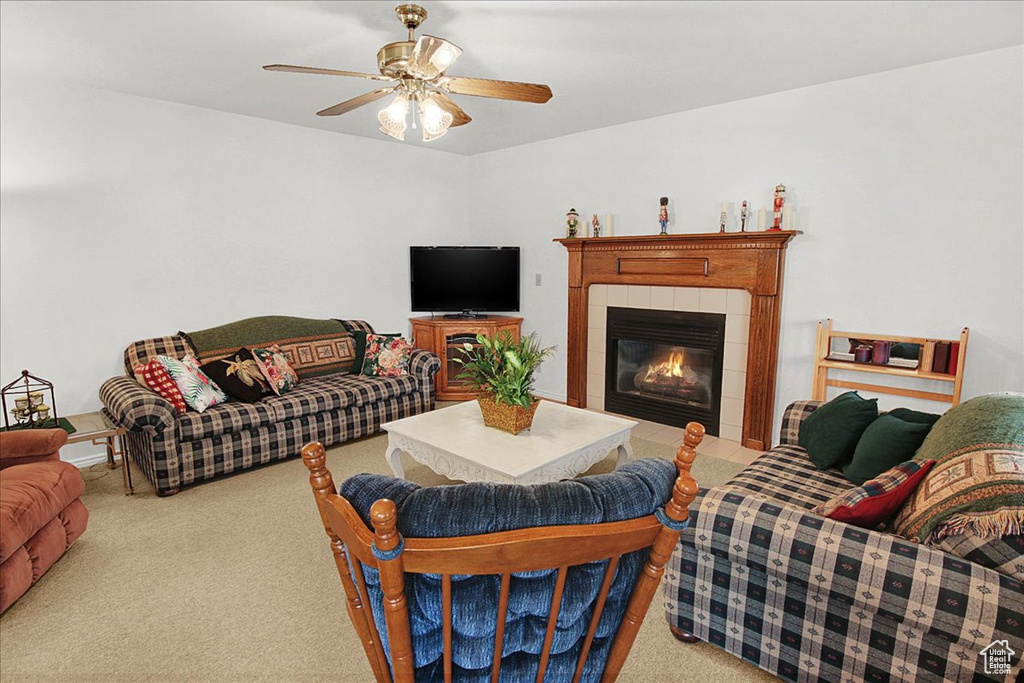 Carpeted living room with ceiling fan and a tiled fireplace