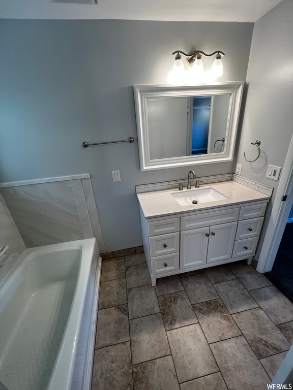 Bathroom featuring tile flooring, vanity, and a bathing tub