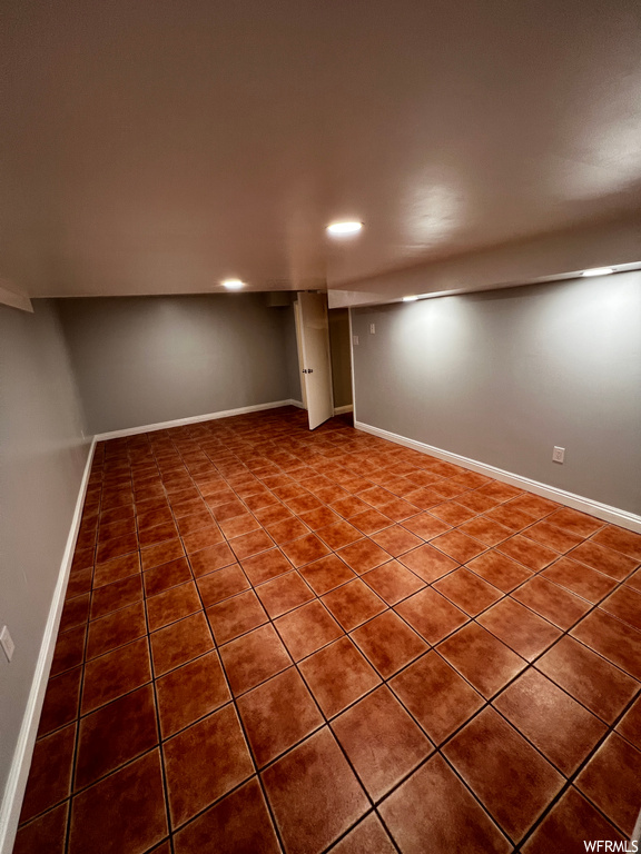 Spare room featuring dark tile floors