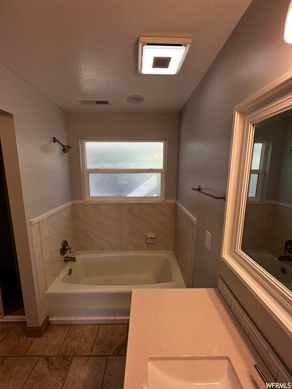 Bathroom with a healthy amount of sunlight, tile floors, and vanity