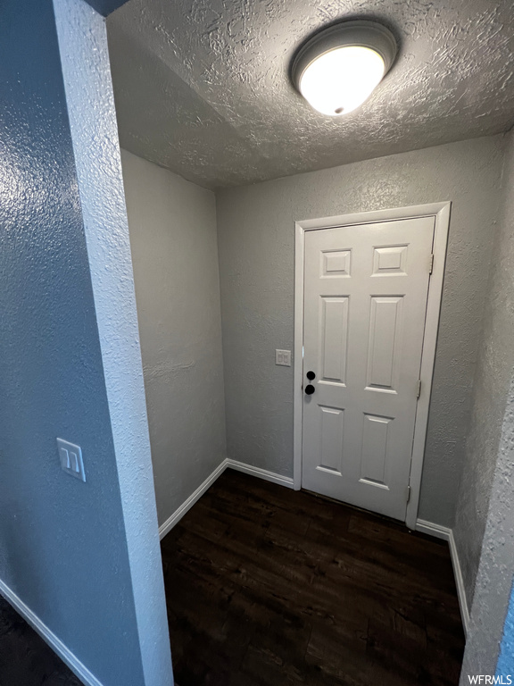Doorway to outside featuring dark hardwood / wood-style flooring and a textured ceiling