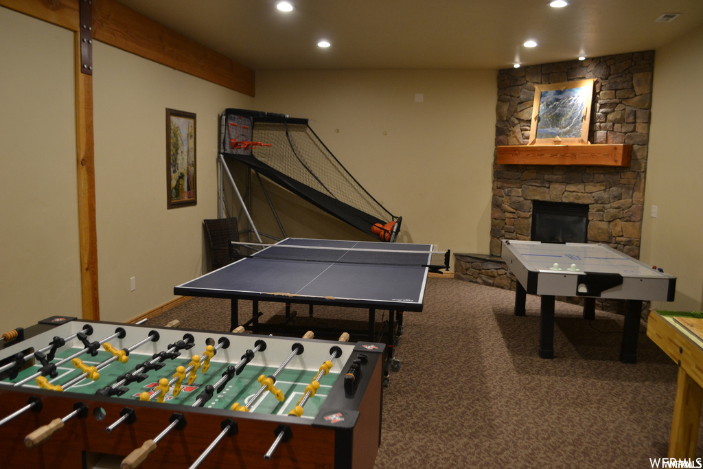 Recreation room with a fireplace and carpet floors