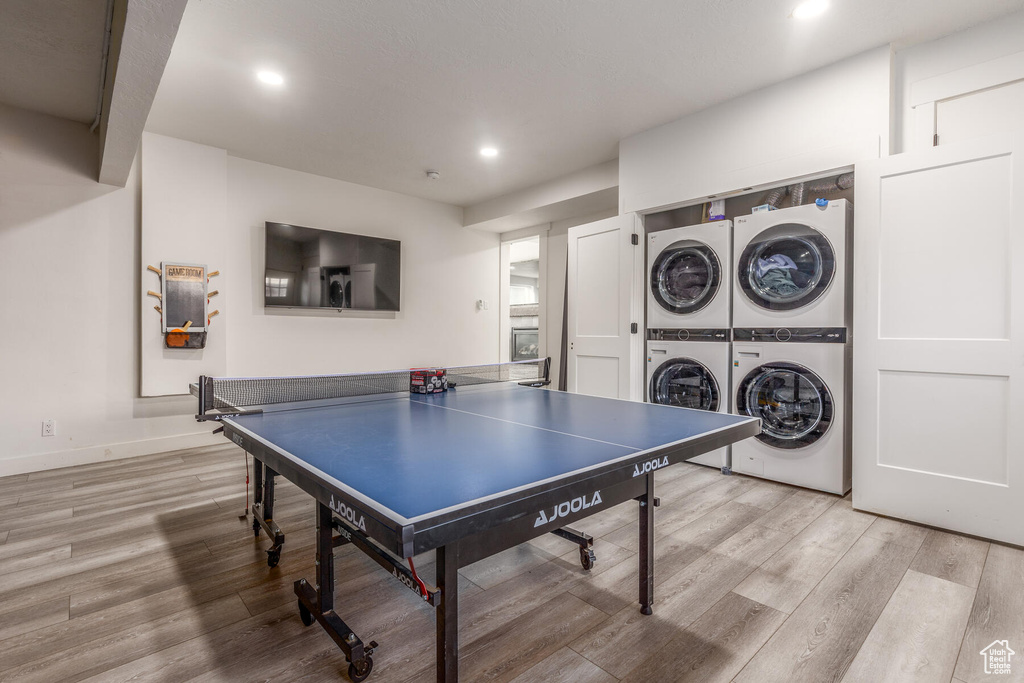 Recreation room with separate washer and dryer, light hardwood / wood-style flooring, and stacked washer / dryer