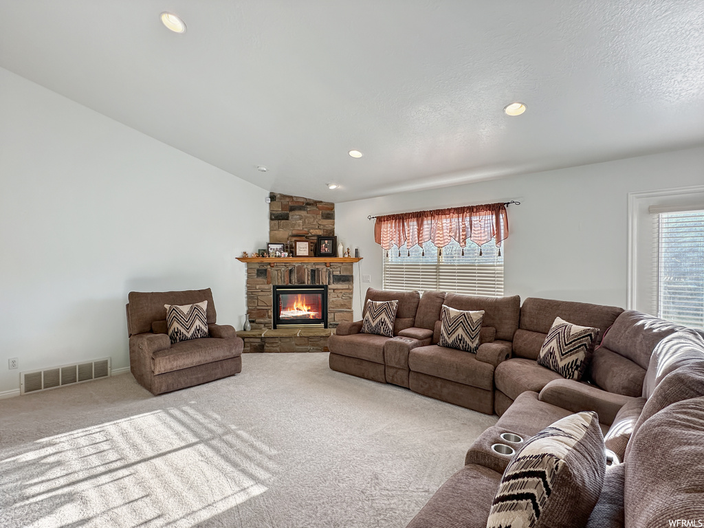 Carpeted living room featuring a textured ceiling and a fireplace
