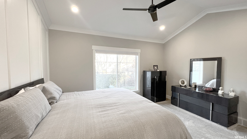 Bedroom featuring lofted ceiling, ceiling fan, light carpet, and crown molding