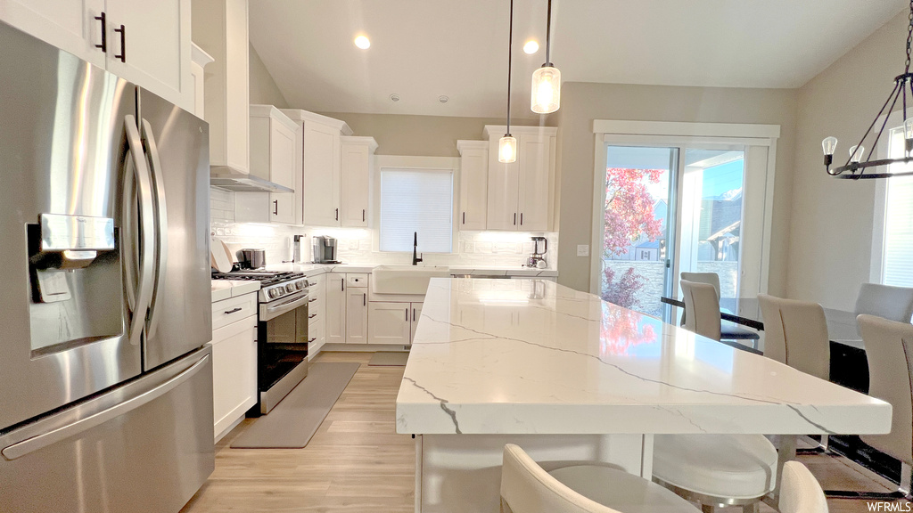 Kitchen featuring light wood-type flooring, sink, appliances with stainless steel finishes, and white cabinets