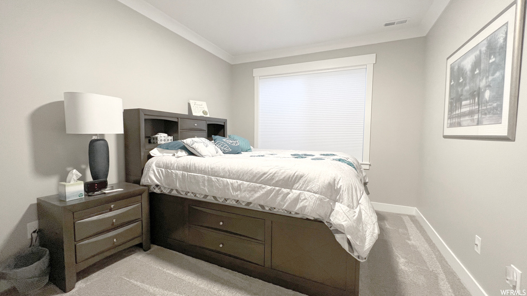 Bedroom featuring ornamental molding and light colored carpet