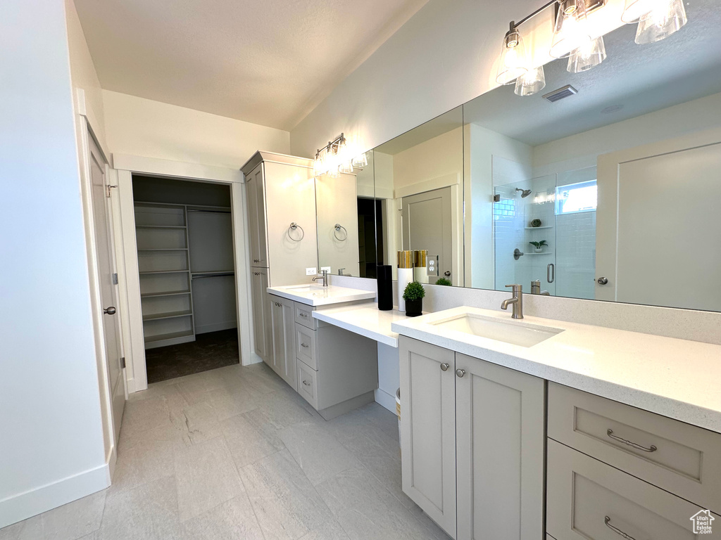 Bathroom with walk in shower, tile flooring, and double sink vanity