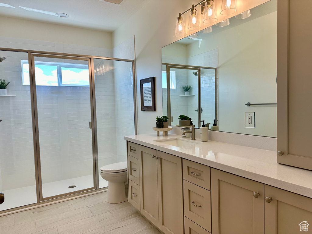Bathroom with tile flooring, an enclosed shower, toilet, and large vanity