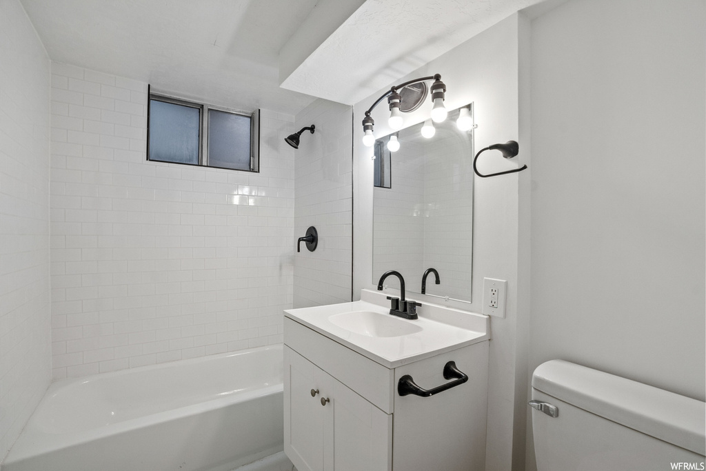 Full bathroom featuring toilet, tiled shower / bath combo, and oversized vanity