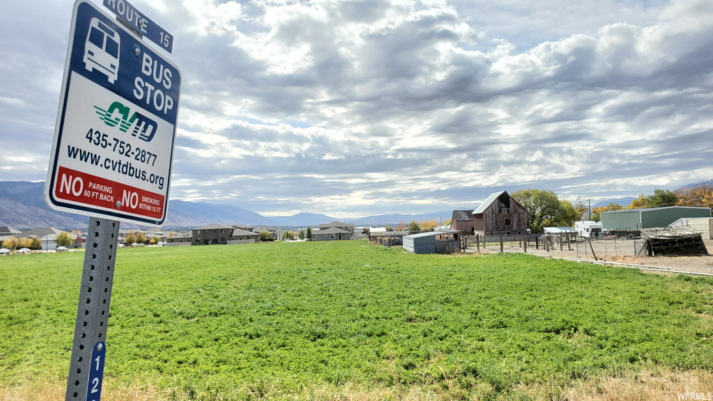 Community / neighborhood sign with a lawn and a mountain view