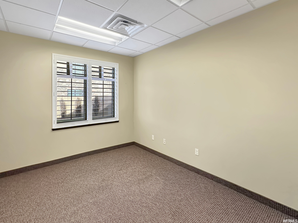 Carpeted empty room with a drop ceiling