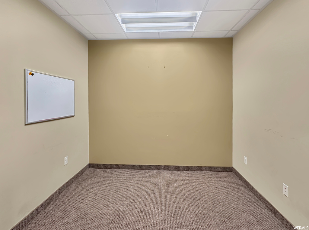 Unfurnished room with a paneled ceiling and carpet