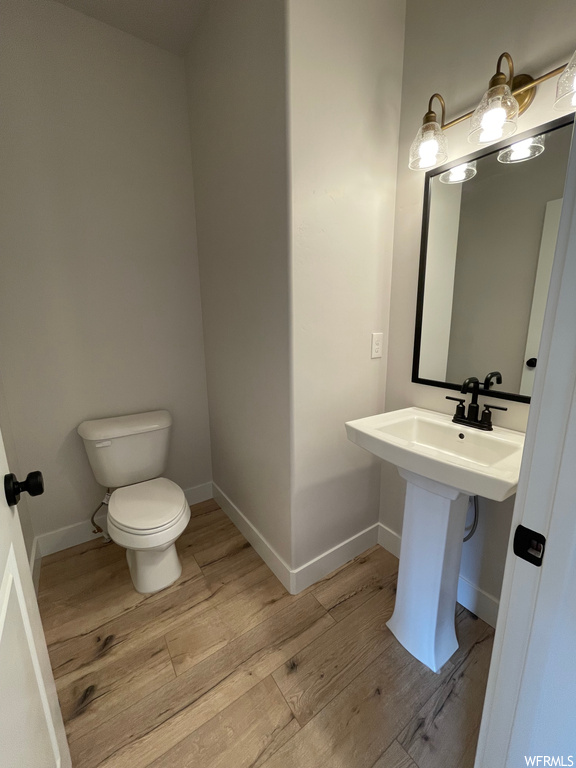 Bathroom with toilet, sink, and wood-type flooring