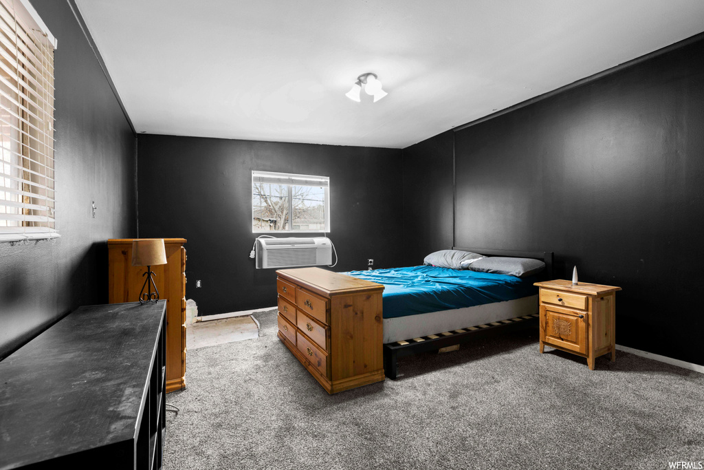 Bedroom featuring light colored carpet and a wall mounted AC