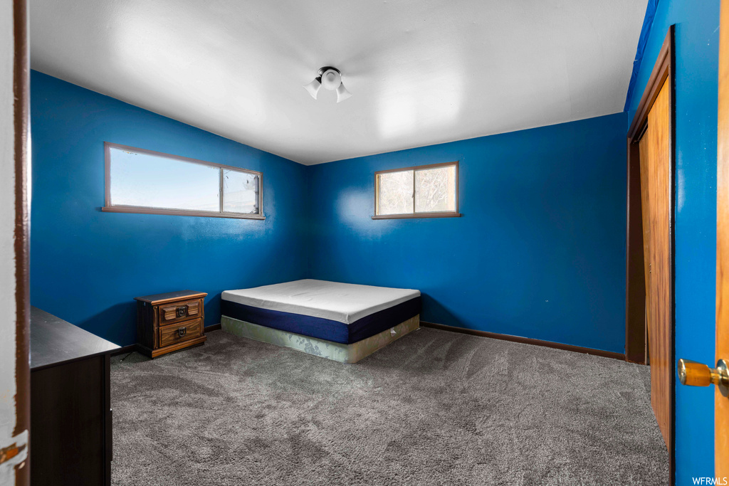 Unfurnished bedroom featuring dark carpet