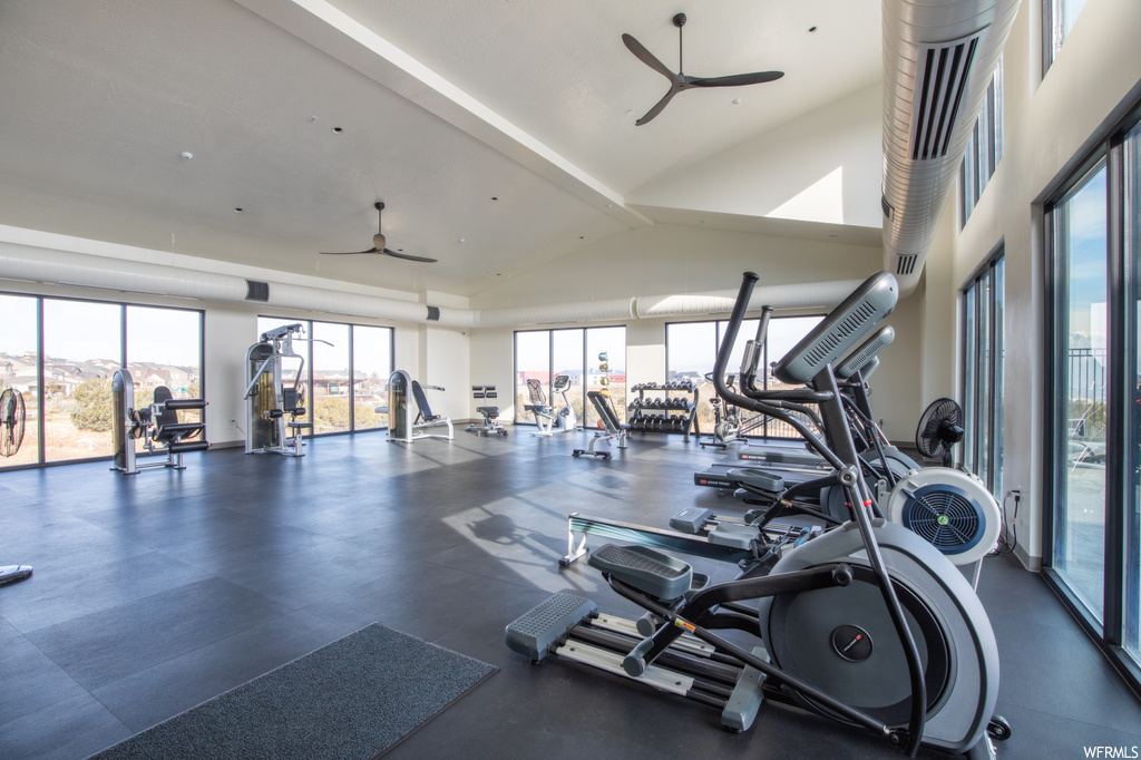 Workout area with ceiling fan and high vaulted ceiling