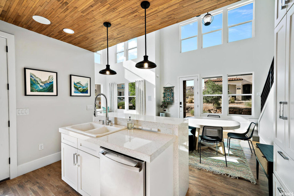 Kitchen featuring dark hardwood / wood-style flooring, hanging light fixtures, sink, and dishwasher