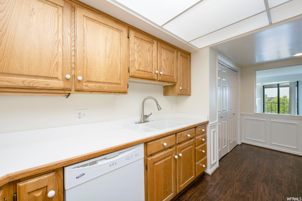 Kitchen with dark hardwood / wood-style flooring, sink, and white dishwasher
