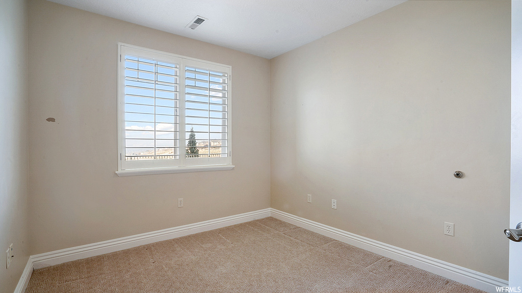 Unfurnished room featuring a healthy amount of sunlight and light colored carpet