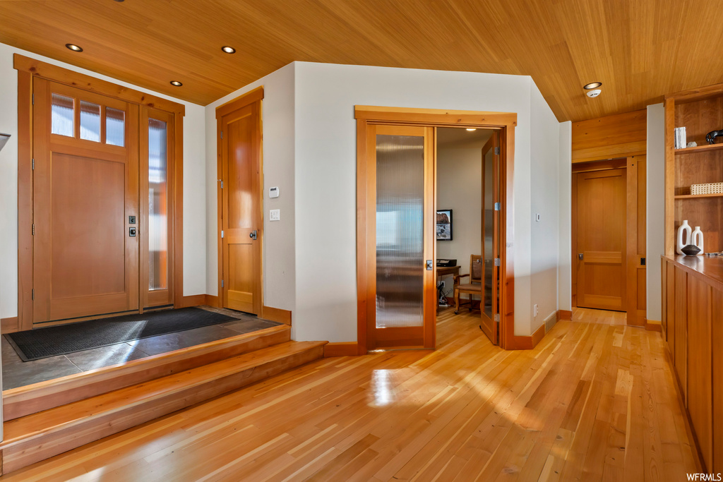 Foyer entrance featuring light hardwood / wood-style flooring and wooden ceiling