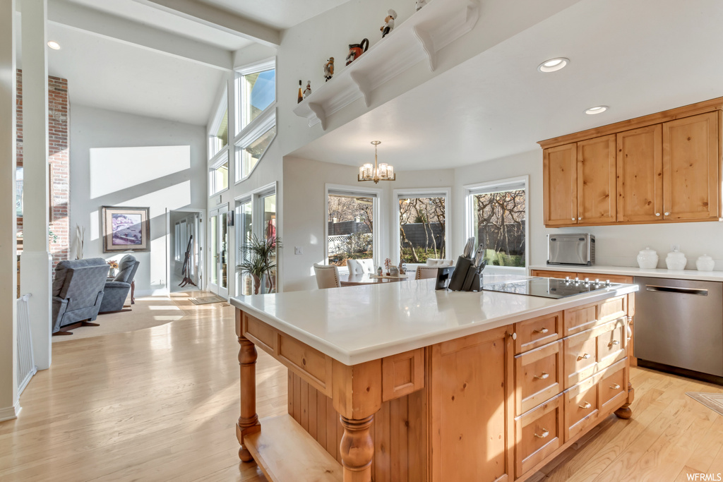 Kitchen with a center island, pendant lighting, light hardwood / wood-style floors, and dishwasher