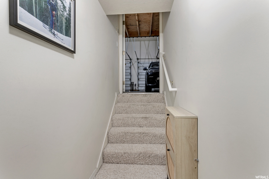 Stairway featuring light carpet
