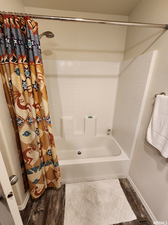 Bathroom with shower / bath combo with shower curtain and hardwood / wood-style floors