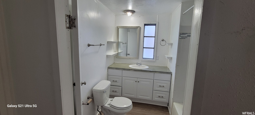 Bathroom with toilet, vanity, and hardwood / wood-style floors