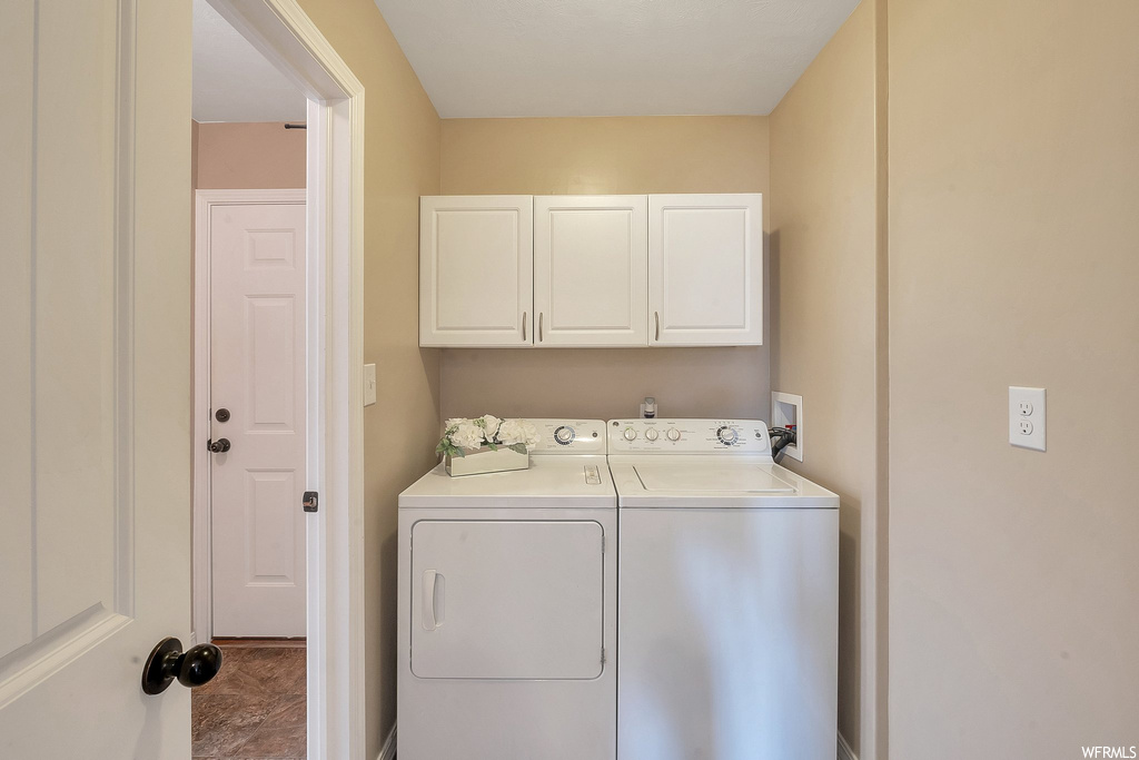Clothes washing area featuring cabinets, separate washer and dryer, and hookup for a washing machine
