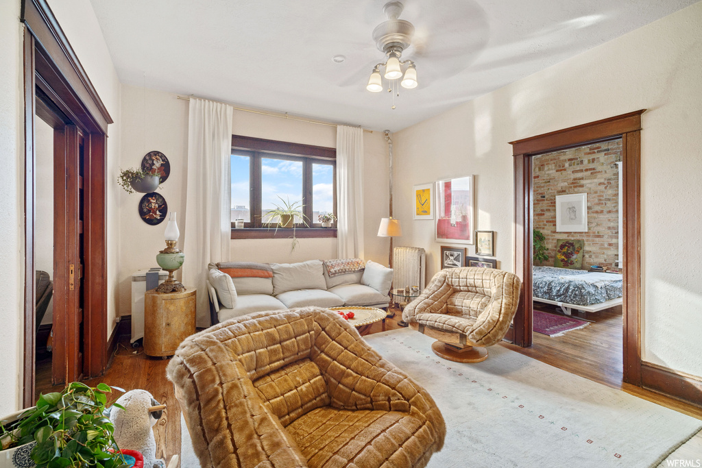 Living room featuring dark hardwood / wood-style floors, ceiling fan, and radiator