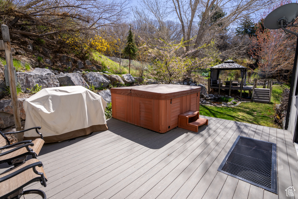 Wooden deck featuring a gazebo, a grill, and a hot tub