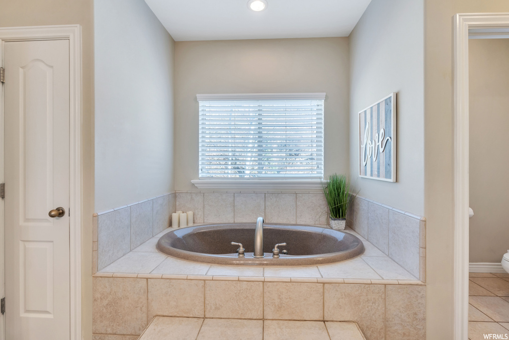 Bathroom featuring tile floors and tiled tub