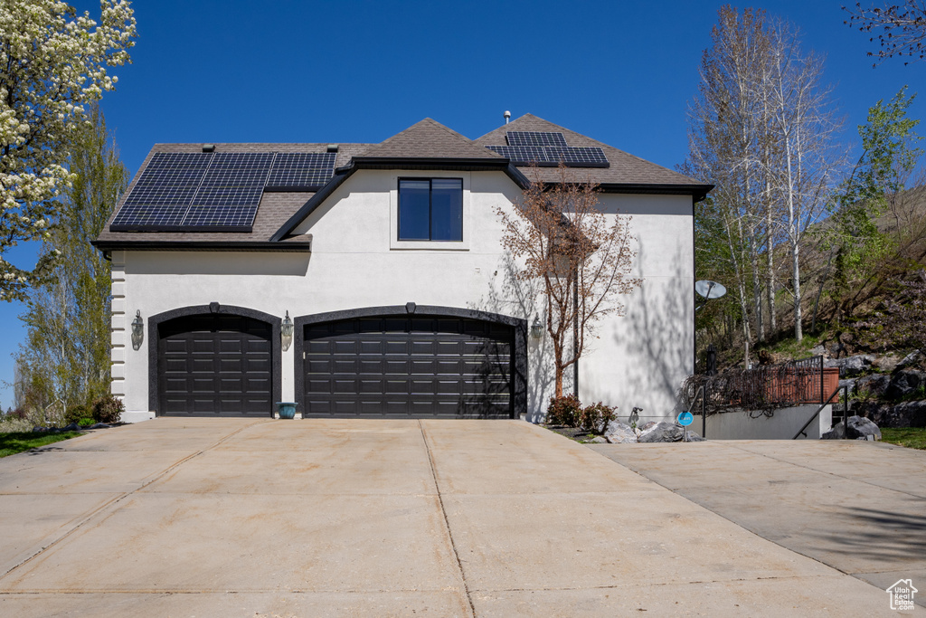View of front of house with a garage and solar panels