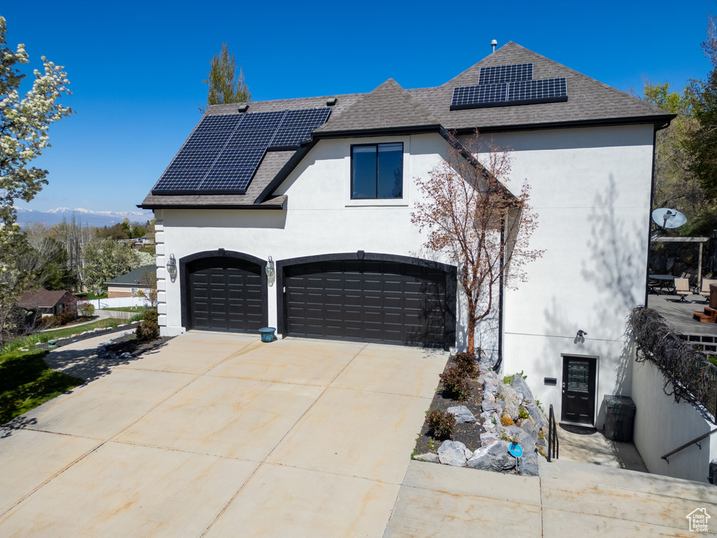Front facade featuring a garage and solar panels