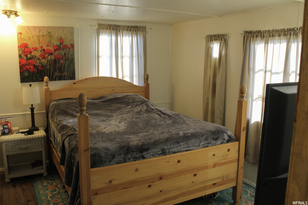 Bedroom featuring dark hardwood / wood-style floors and multiple windows