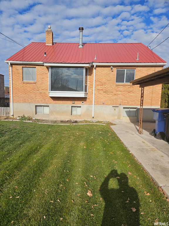 Rear view of property with a yard