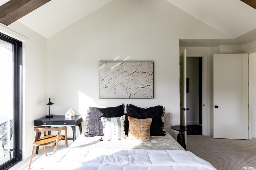 Carpeted bedroom featuring multiple windows and lofted ceiling