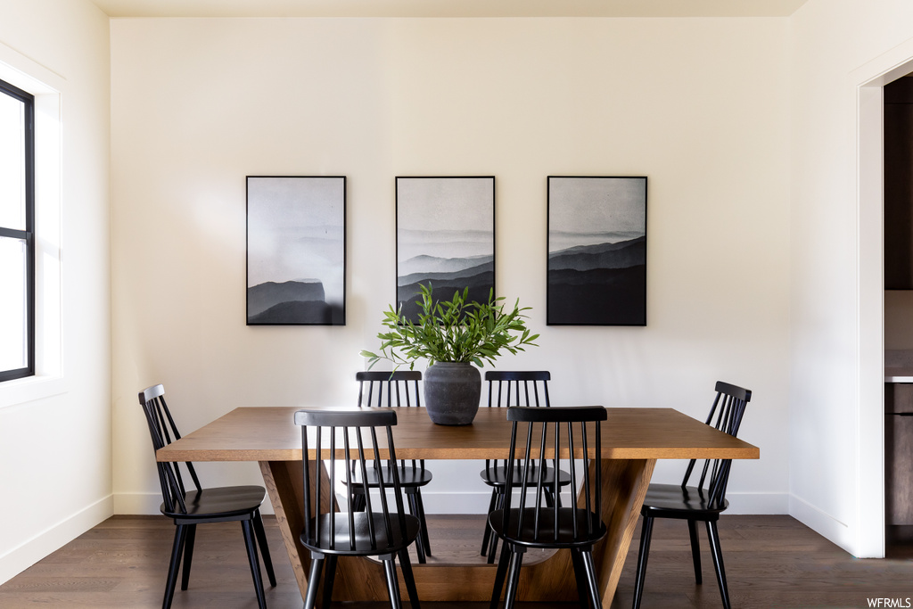 Dining space with dark hardwood / wood-style floors