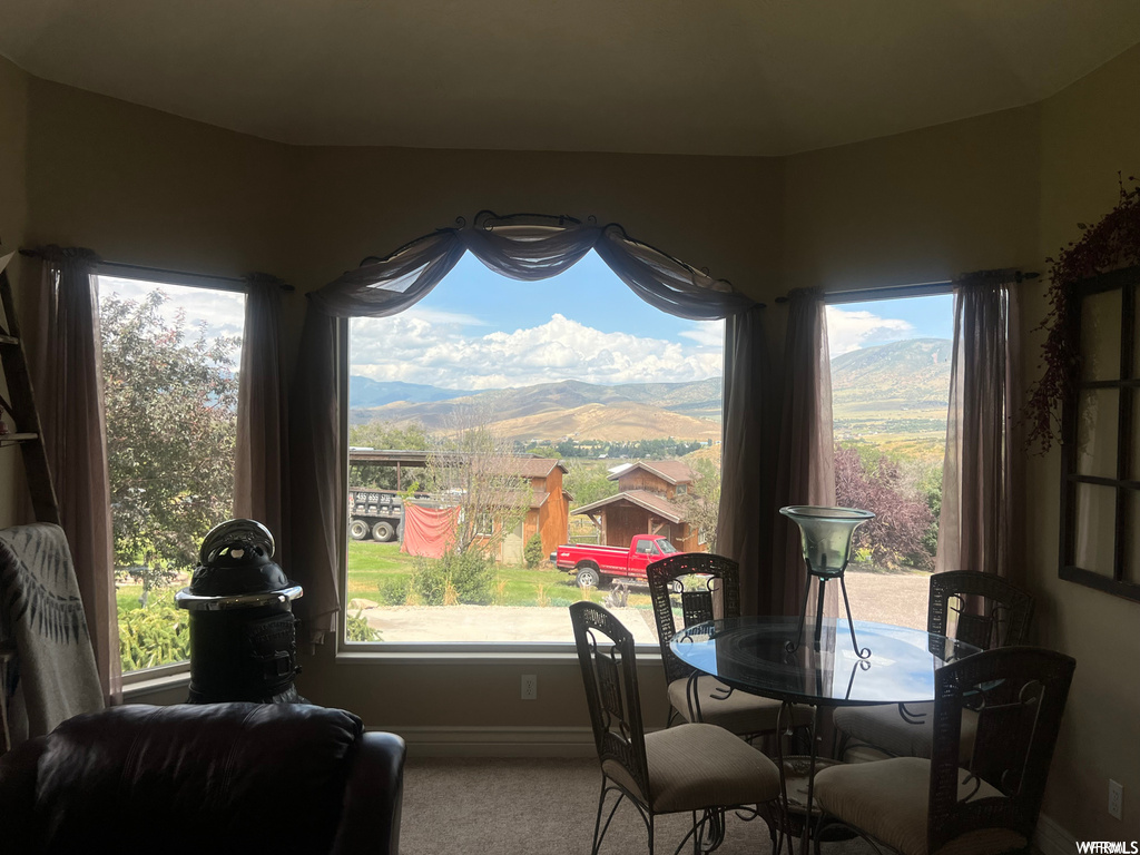 Carpeted dining space featuring a mountain view