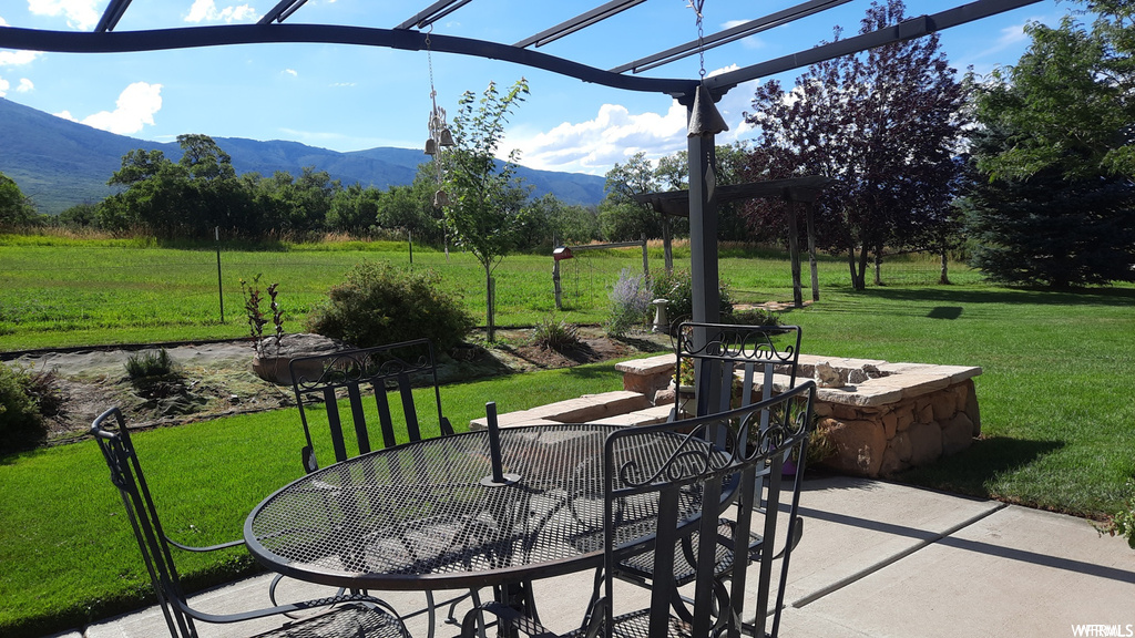 View of patio / terrace featuring a fire pit and a mountain view