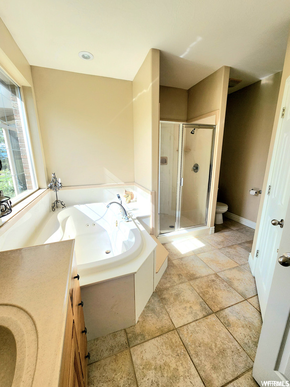 Bathroom with separate shower and tub, vanity, and tile floors