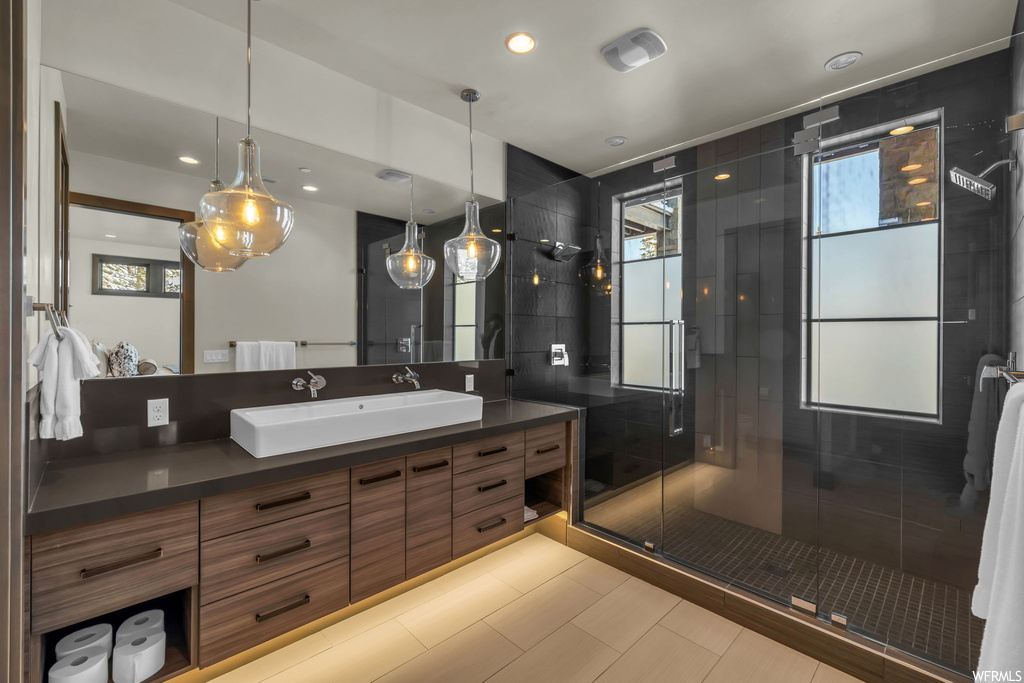 Bathroom with oversized vanity, tile floors, and an enclosed shower
