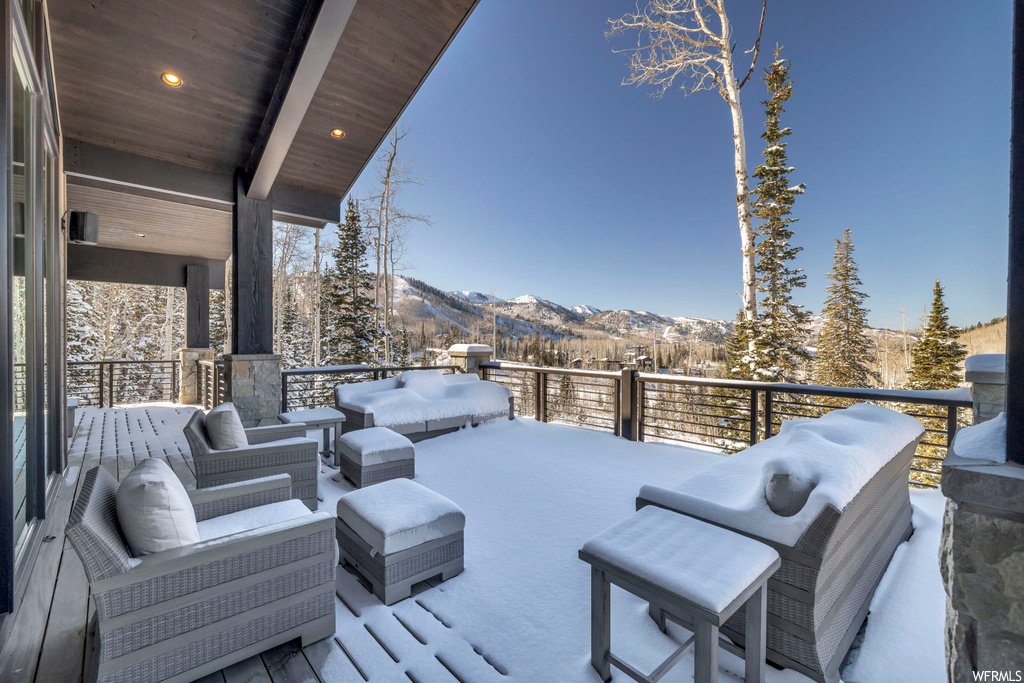 Snow covered deck featuring outdoor lounge area and a mountain view