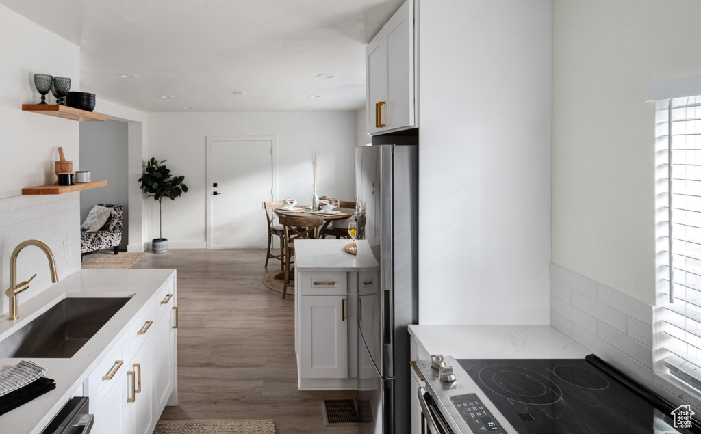 Kitchen featuring dark hardwood / wood-style flooring, white cabinets, and sink