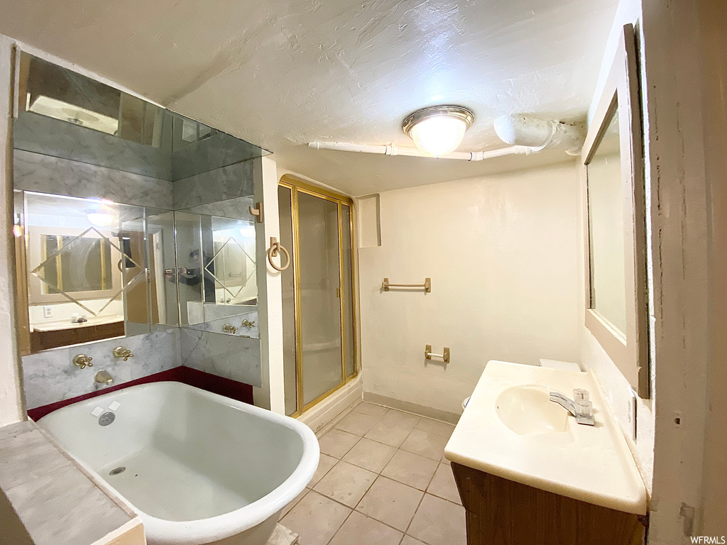 Bathroom with separate shower and tub, tile floors, and oversized vanity