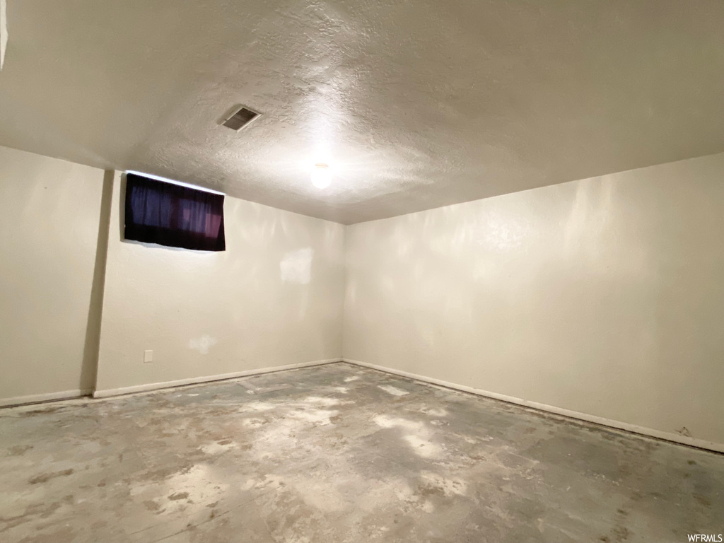 Basement featuring a textured ceiling