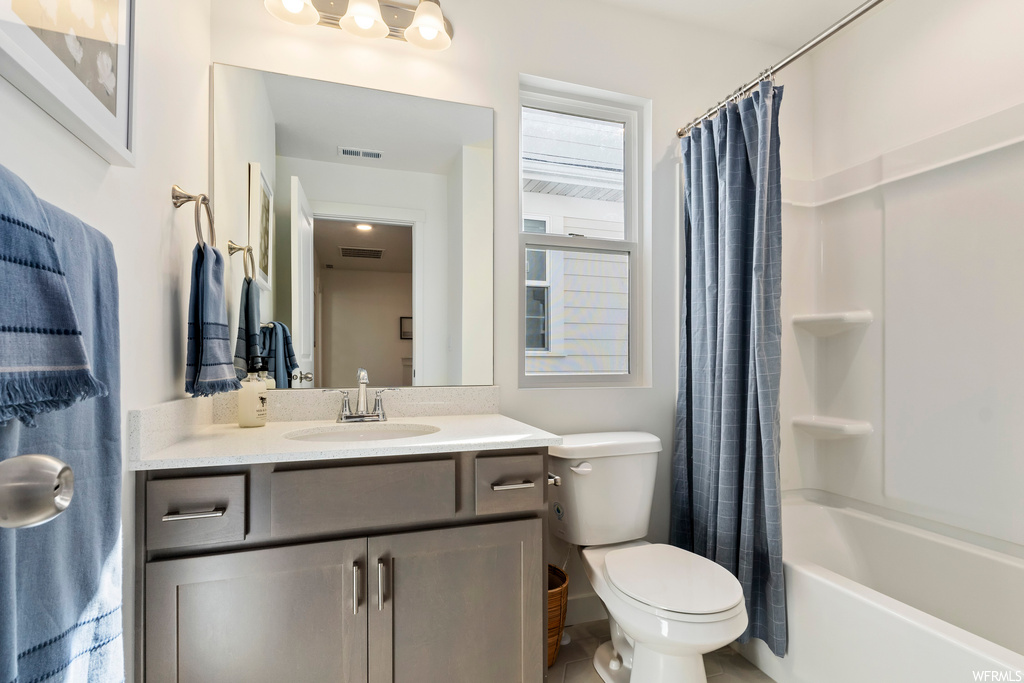 Full bathroom with shower / bath combination with curtain, vanity, toilet, and tile floors