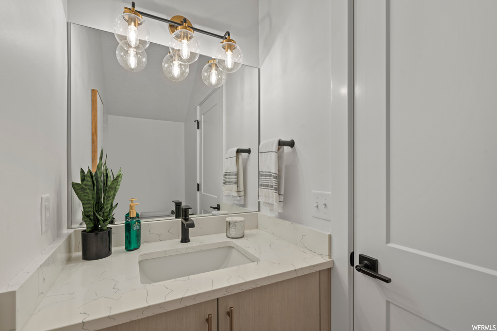 Bathroom featuring a chandelier and vanity
