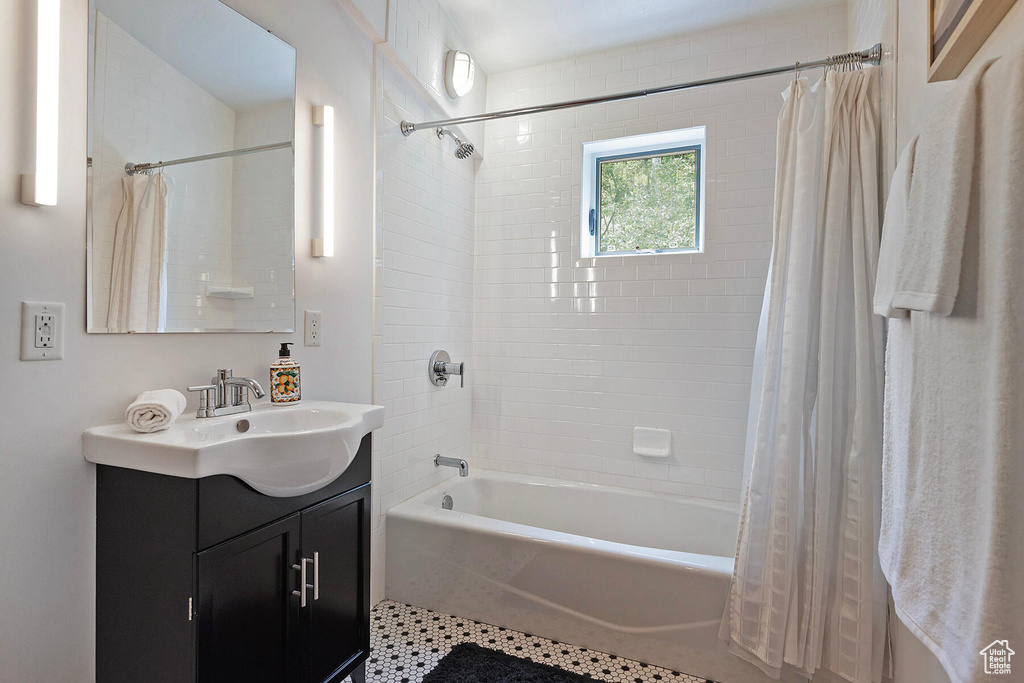 Bathroom featuring large vanity and shower / tub combo